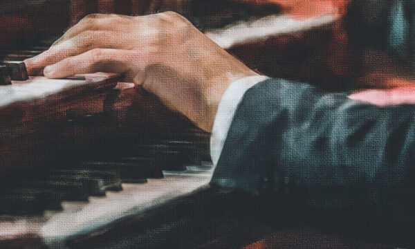 The hand on the keys of the piano.