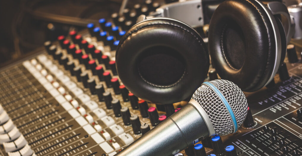 Close up instruments music background concept.Single microphone with headphones on sound mixer board in home recording studio.Free space for creative design text & wording mock up template.