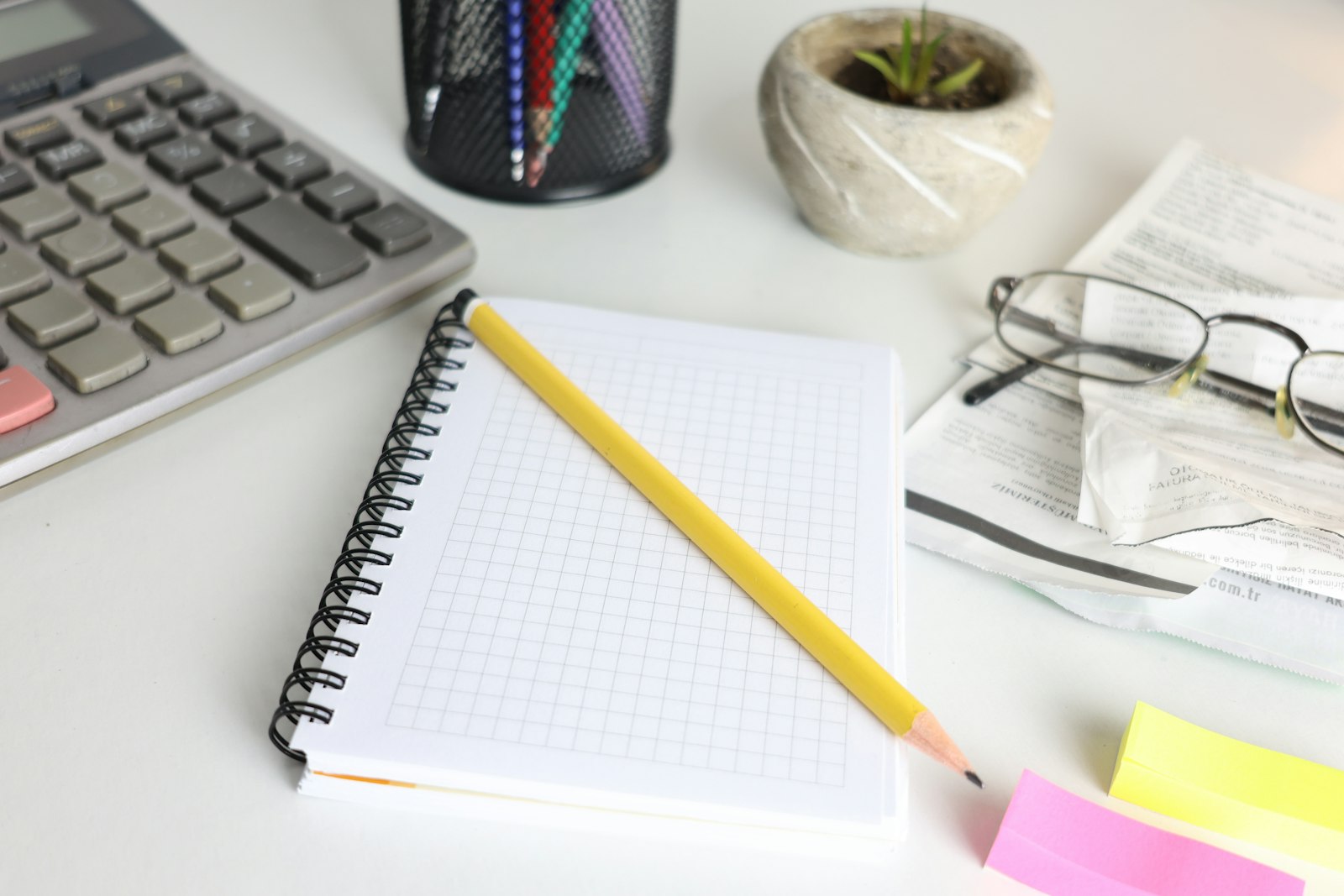 Bureau avec calculatrice, carnet et crayon pour établir le budget d’une production musicale