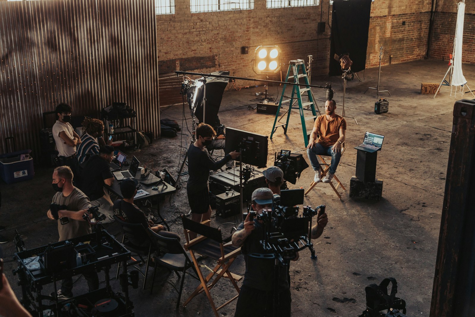 Équipe de tournage réunie autour d’une caméra lors de la réalisation d’un clip