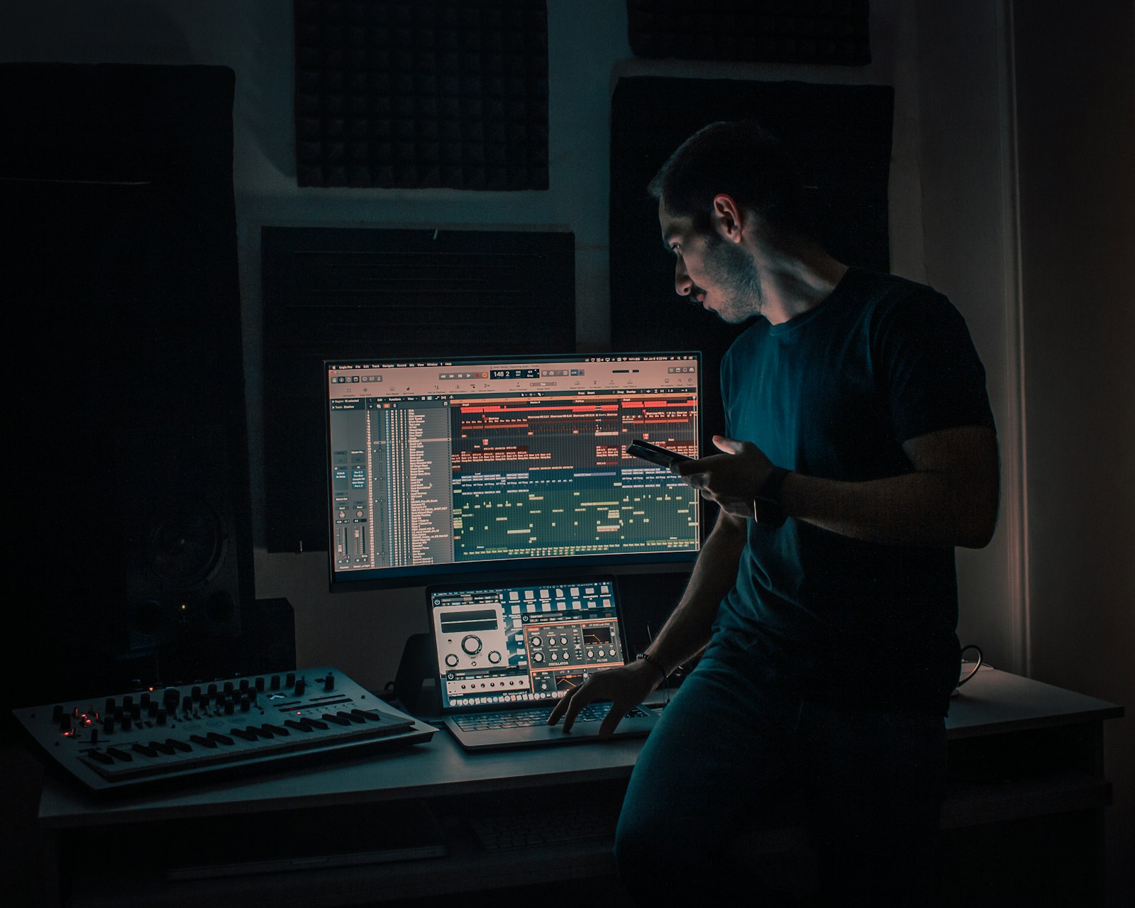 Jeune réalisateur assis devant son ordinateur dans un home studio, la nuit