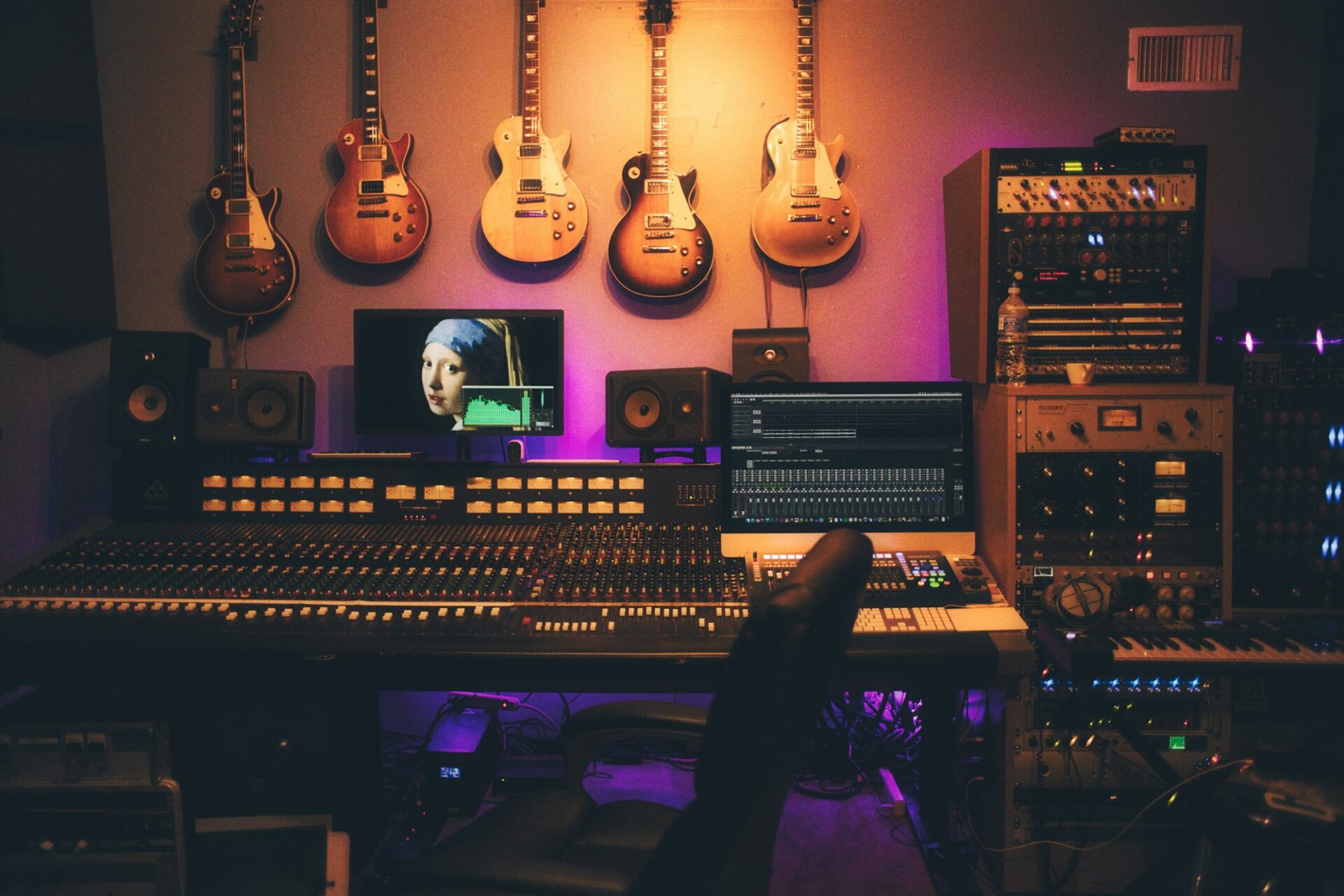 Studio d’enregistrement avec une grande console de mixage et des guitares accrochées au mur
