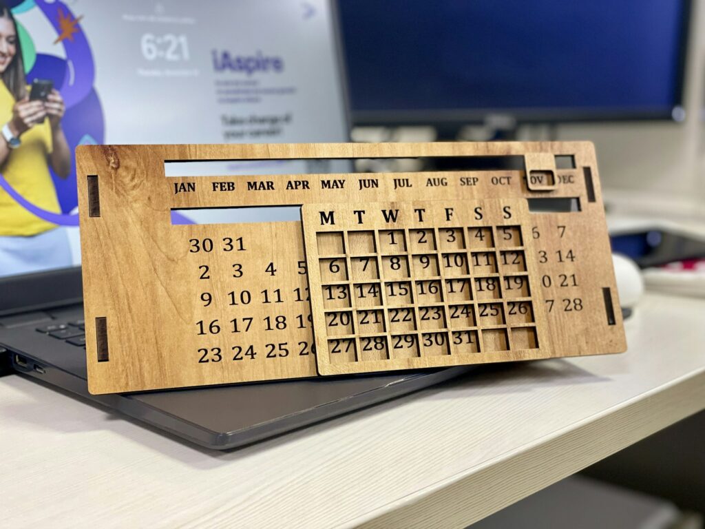 Calendrier en bois posé sur un ordinateur portable, pour planifier une sortie musicale