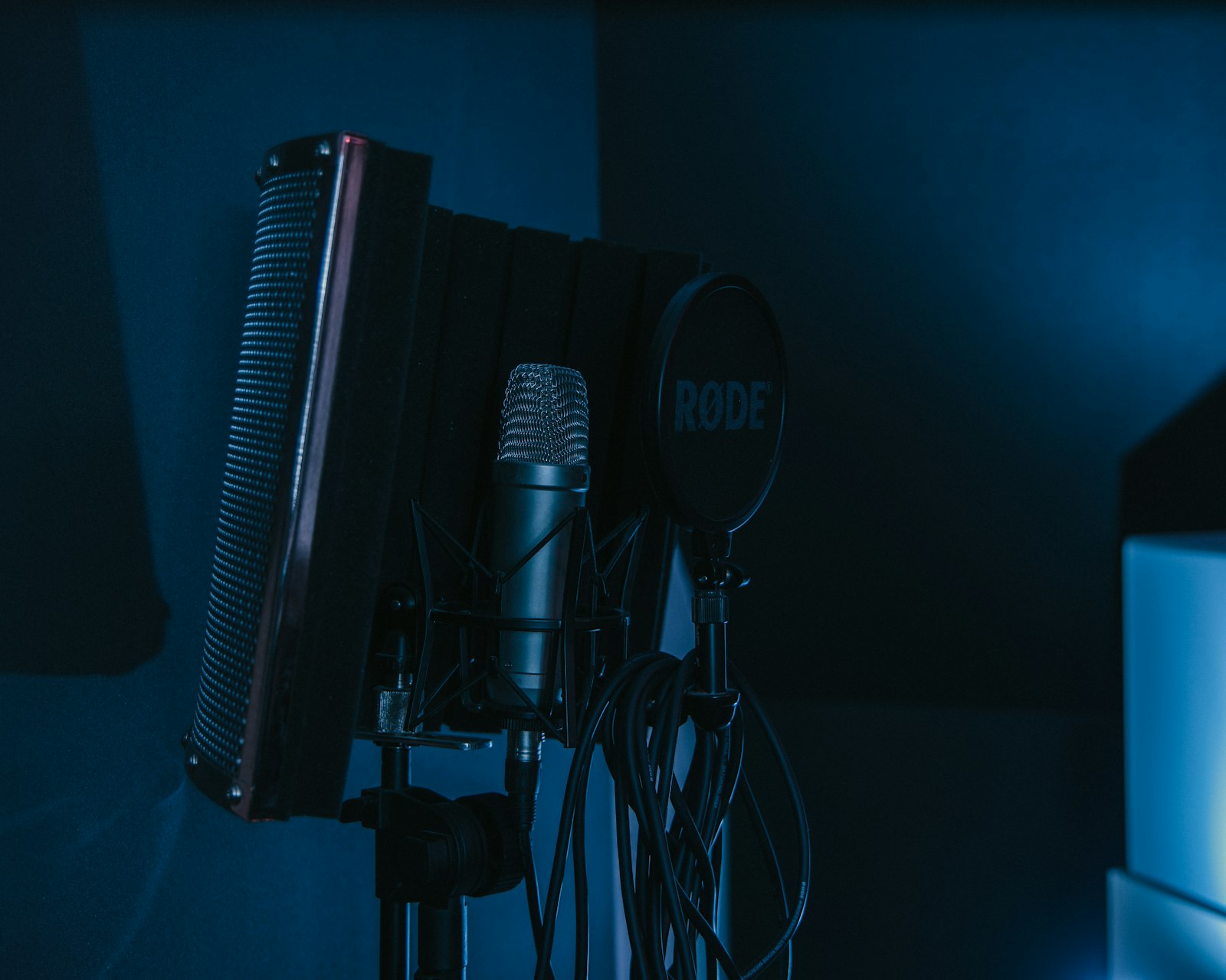 Microphone sur pied dans un studio plongé dans une lumière bleue