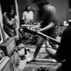 Groupe de musiciens jouant ensemble dans une pièce sombre