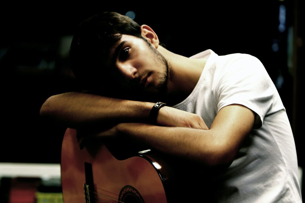 Musicien tenant une guitare acoustique, regard pensif