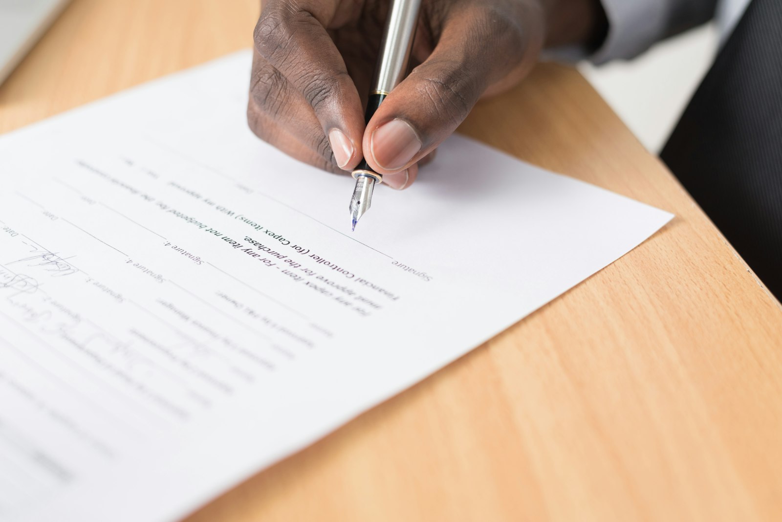 Personne complétant un document sur une table claire