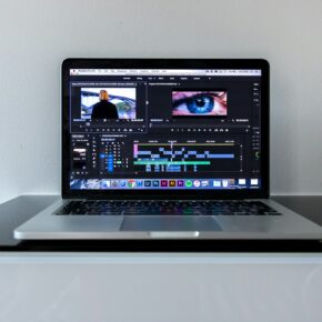 Ordinateur portable ouvert sur un bureau noir, prêt pour l’export des masters