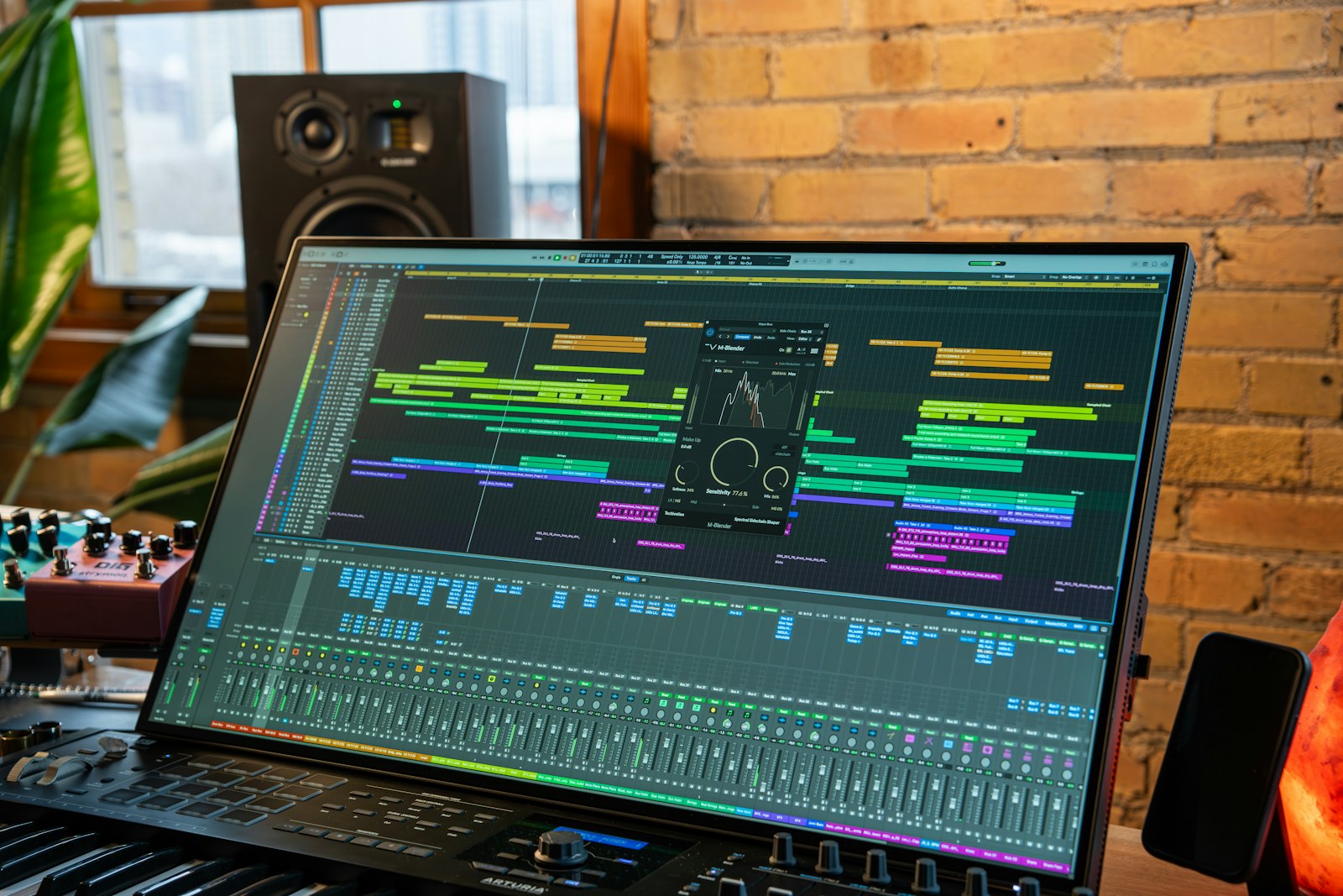 Ordinateur portable posé sur un clavier maître affichant un plug-in audio