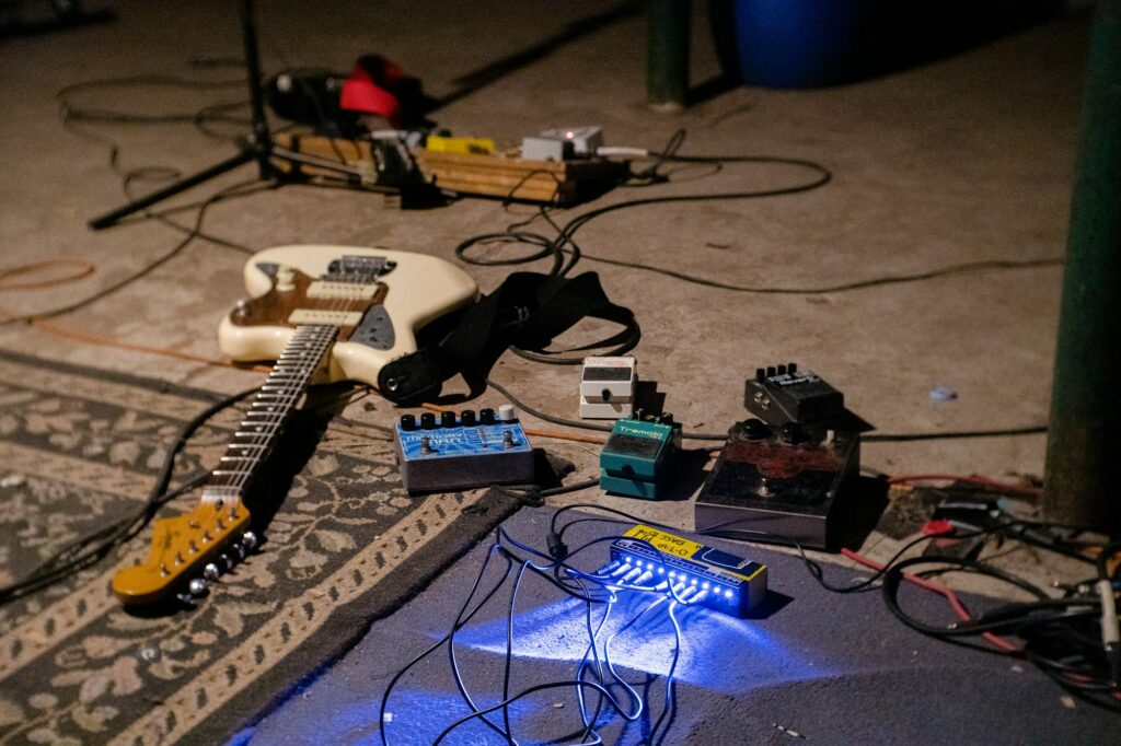 Guitare électrique blanche posée sur un amplificateur bleu