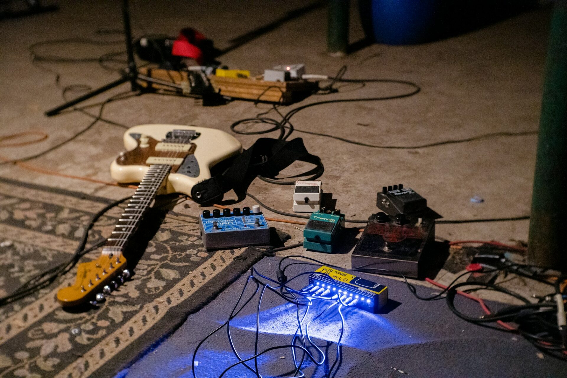 Guitare électrique blanche posée sur un amplificateur bleu