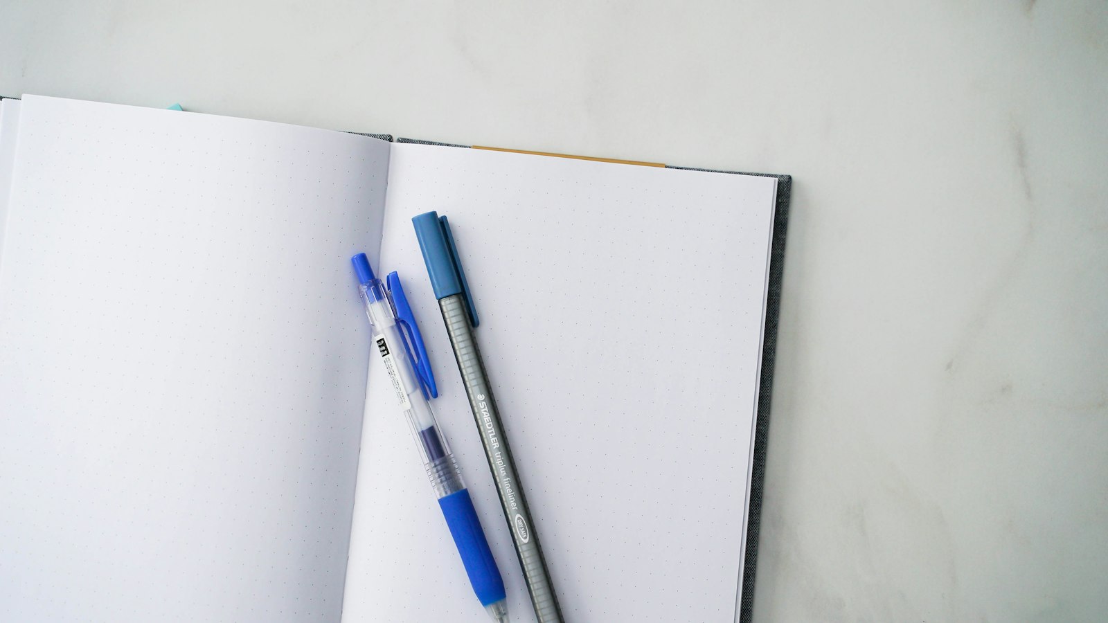 Carnet ouvert et stylo posés sur un bureau clair pour vérifier les informations d’une sortie
