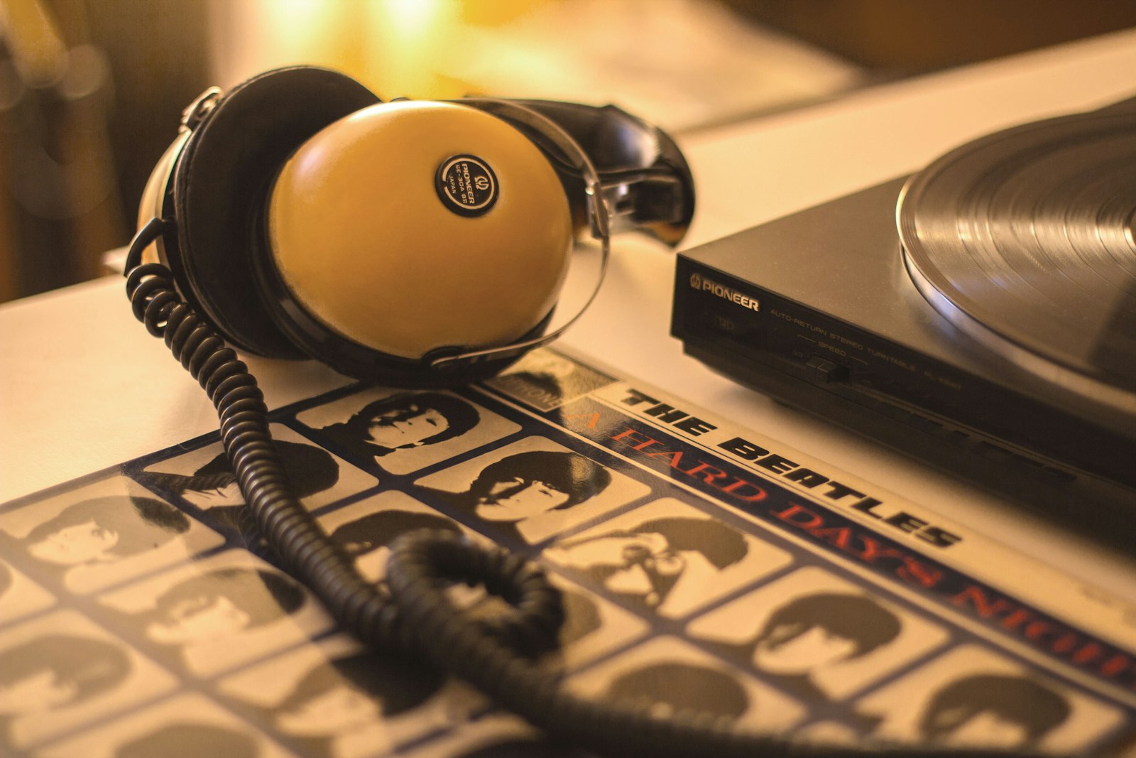 Casque posé sur une platine vinyle dans une ambiance rétro