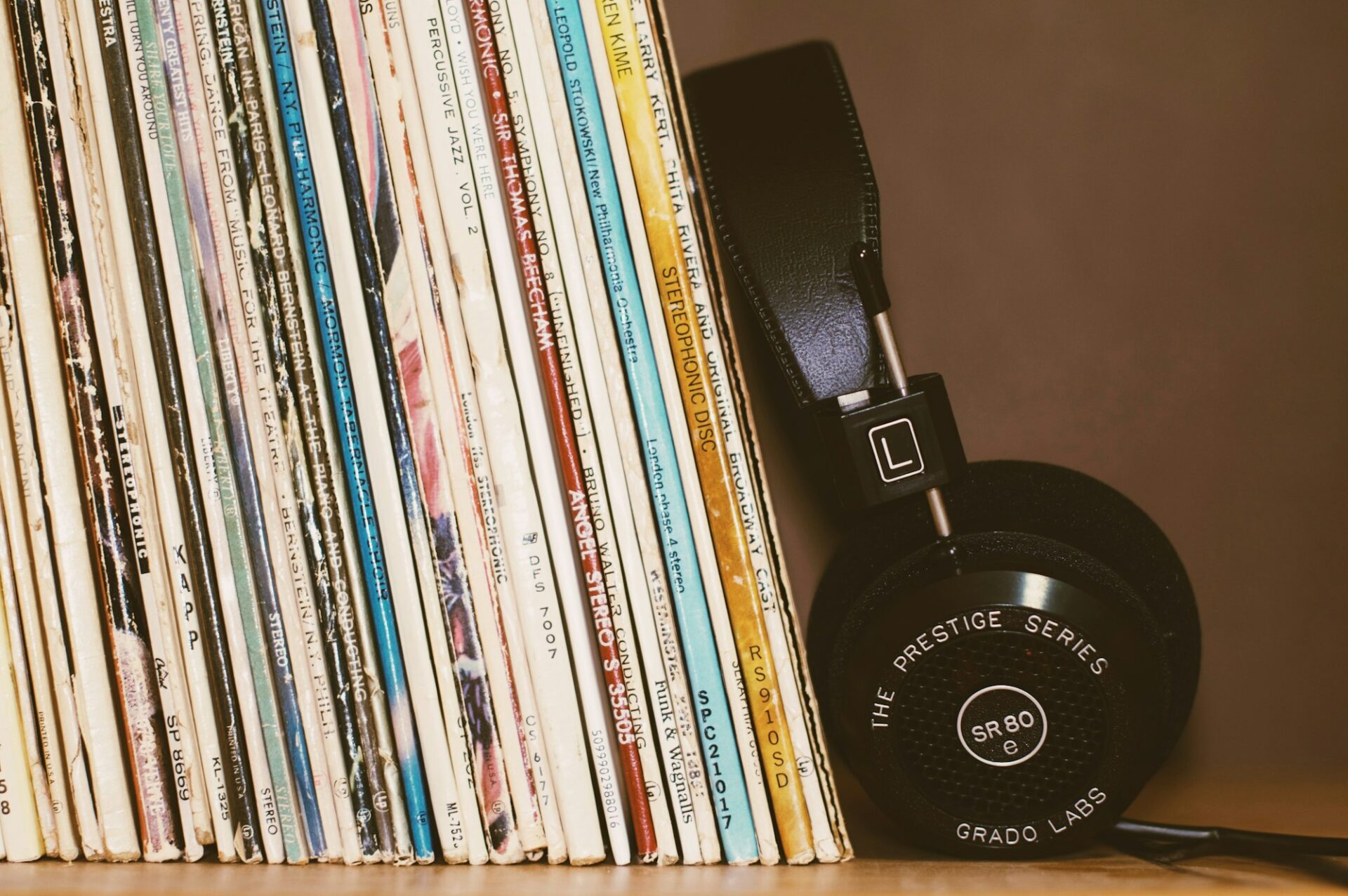 Casque audio posé contre une rangée de disques vinyles
