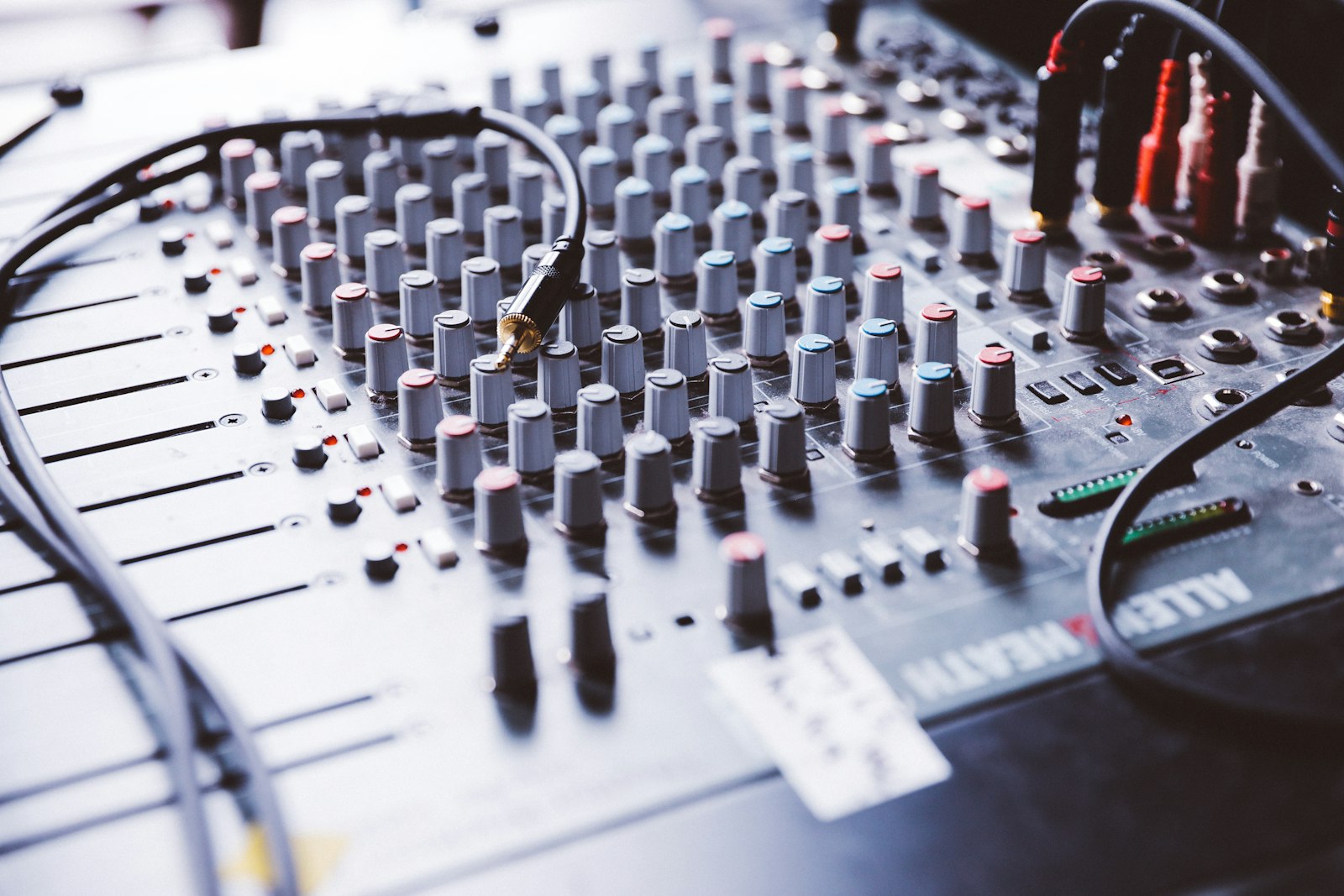 Console de mixage grise photographiée en faible profondeur de champ