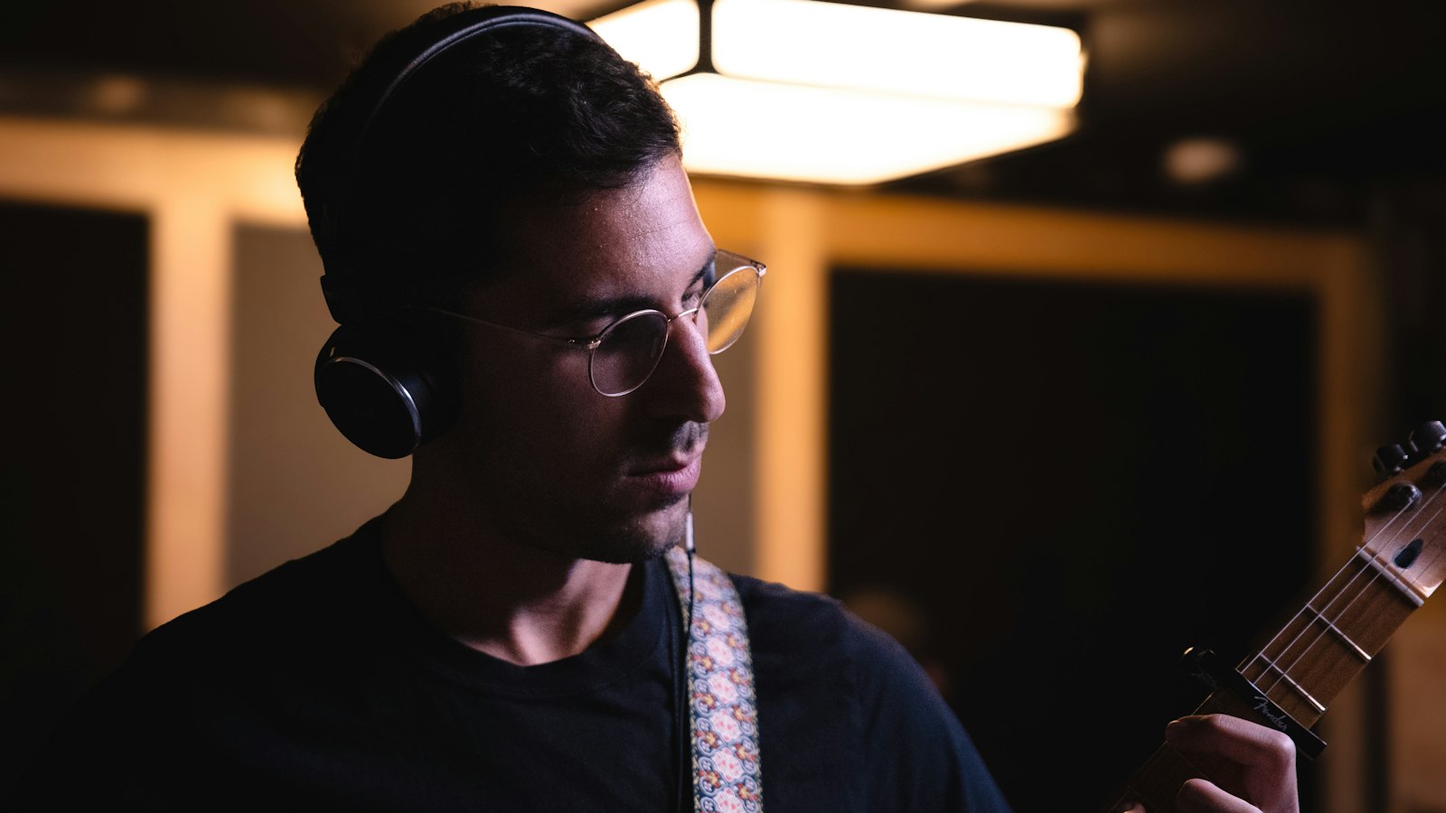 Musicien portant un casque et tenant une guitare en séance