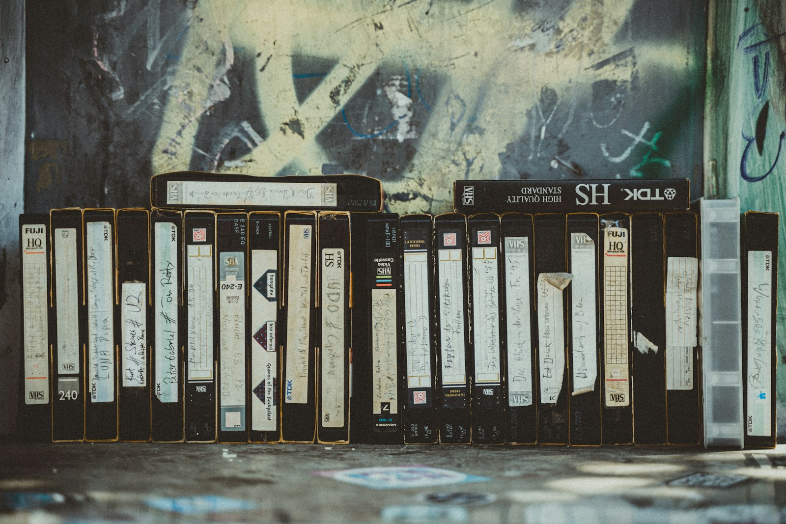 Rangée de disques alignés contre un mur couvert de graffitis