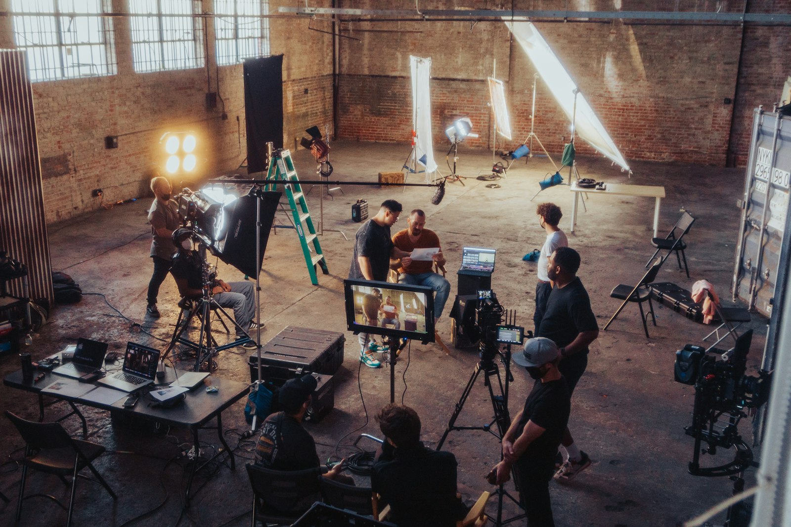 Petite équipe réunie autour d’une caméra pendant un tournage