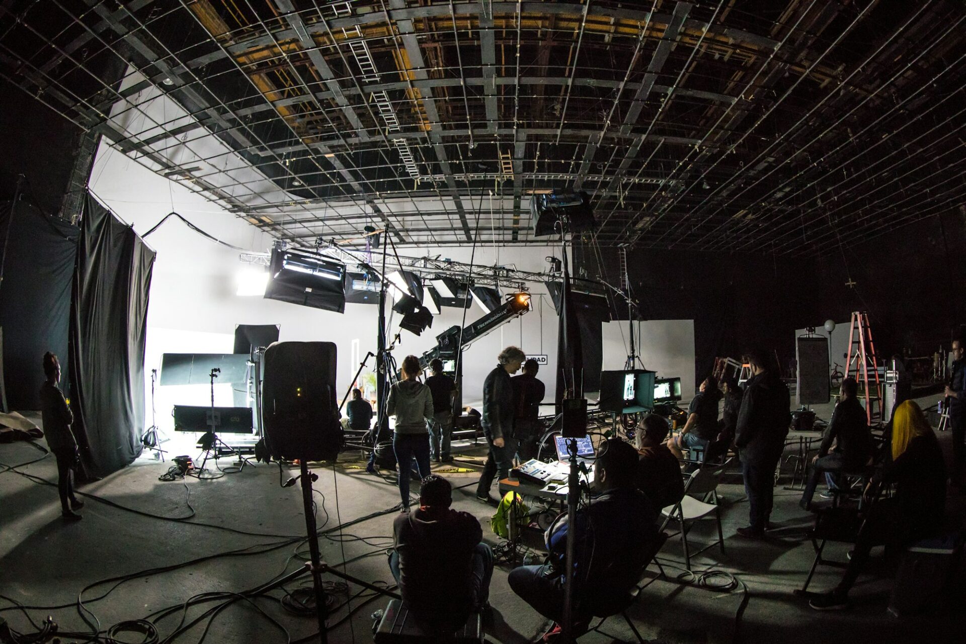Équipe de tournage travaillant sur un plateau équipé de projecteurs et de caméras
