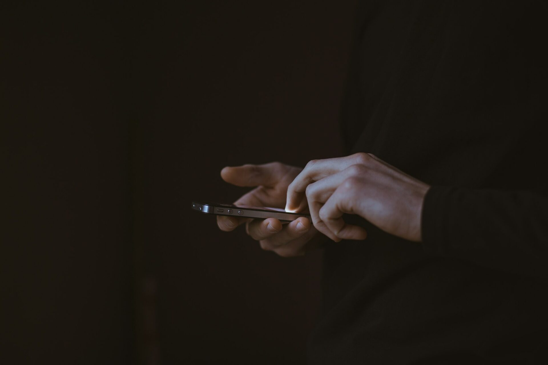 Silhouette d’une personne consultant son smartphone à contre-jour