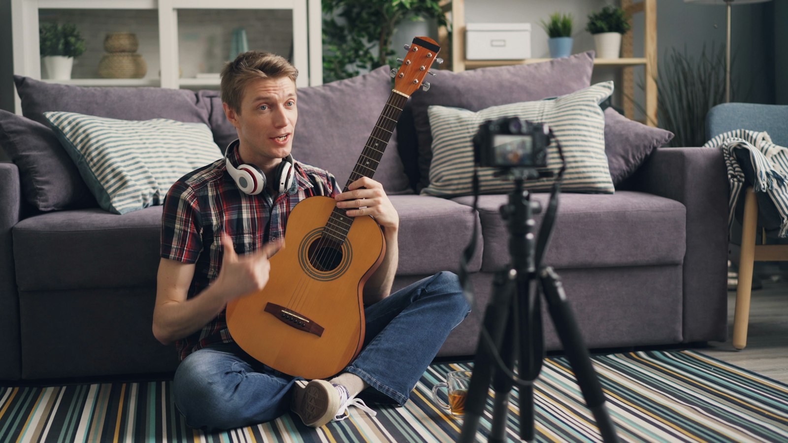 Musicien assis au sol avec sa guitare dans une lumière tamisée
