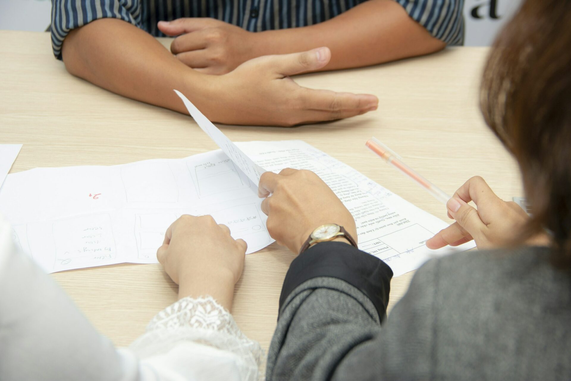 Deux personnes relisant des documents à une table de réunion