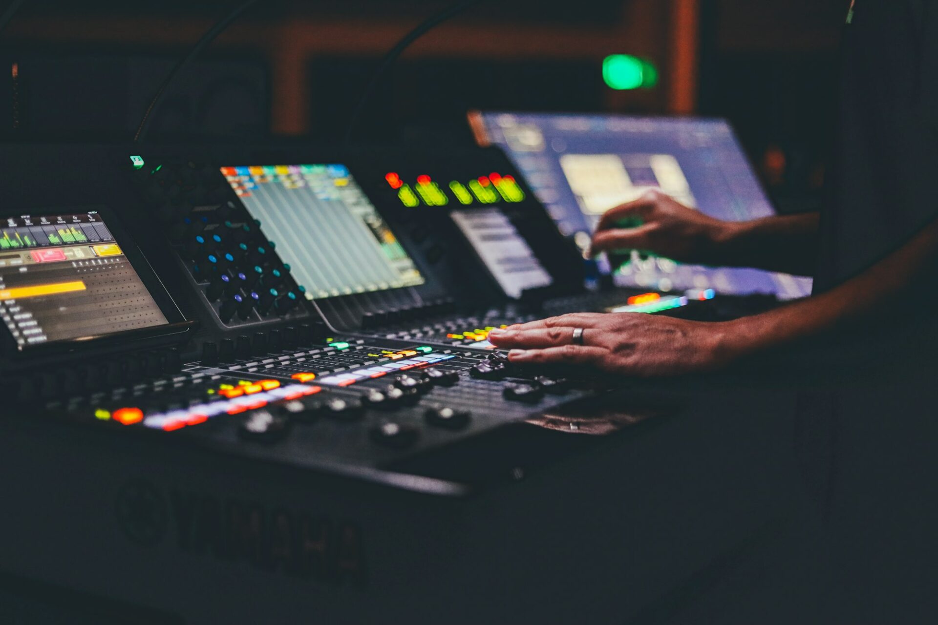 Mains réglant une console de mixage en studio