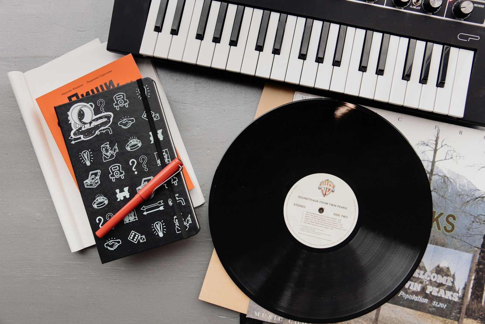 Disque vinyle, clavier et carnet sur le bureau d’un musicien