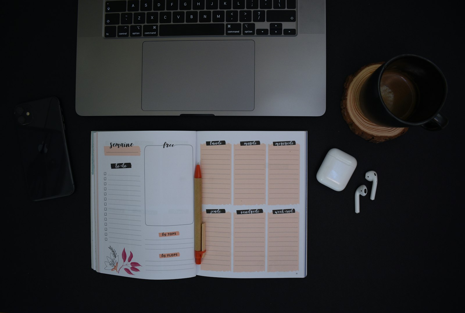 Carnet ouvert et tasse de café sur un bureau sombre