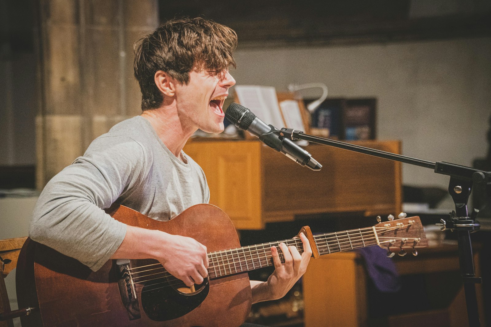 Musicien en pull gris jouant d’une guitare acoustique
