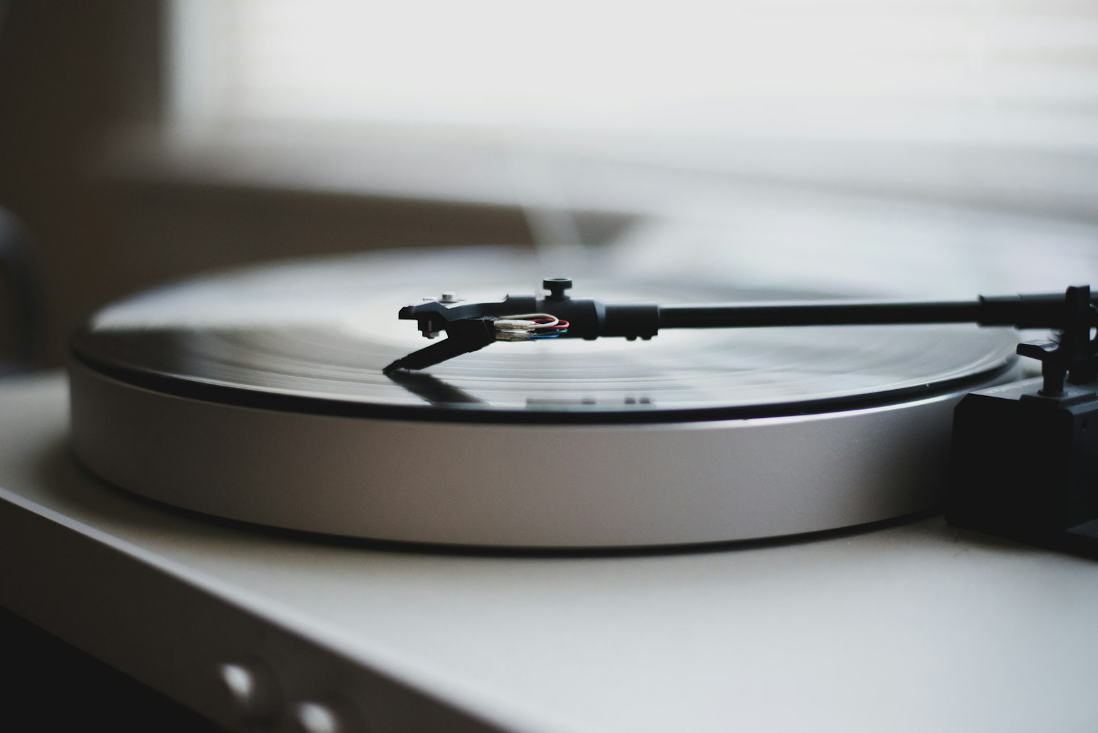 Platine vinyle grise et noire photographiée en plan rapproché