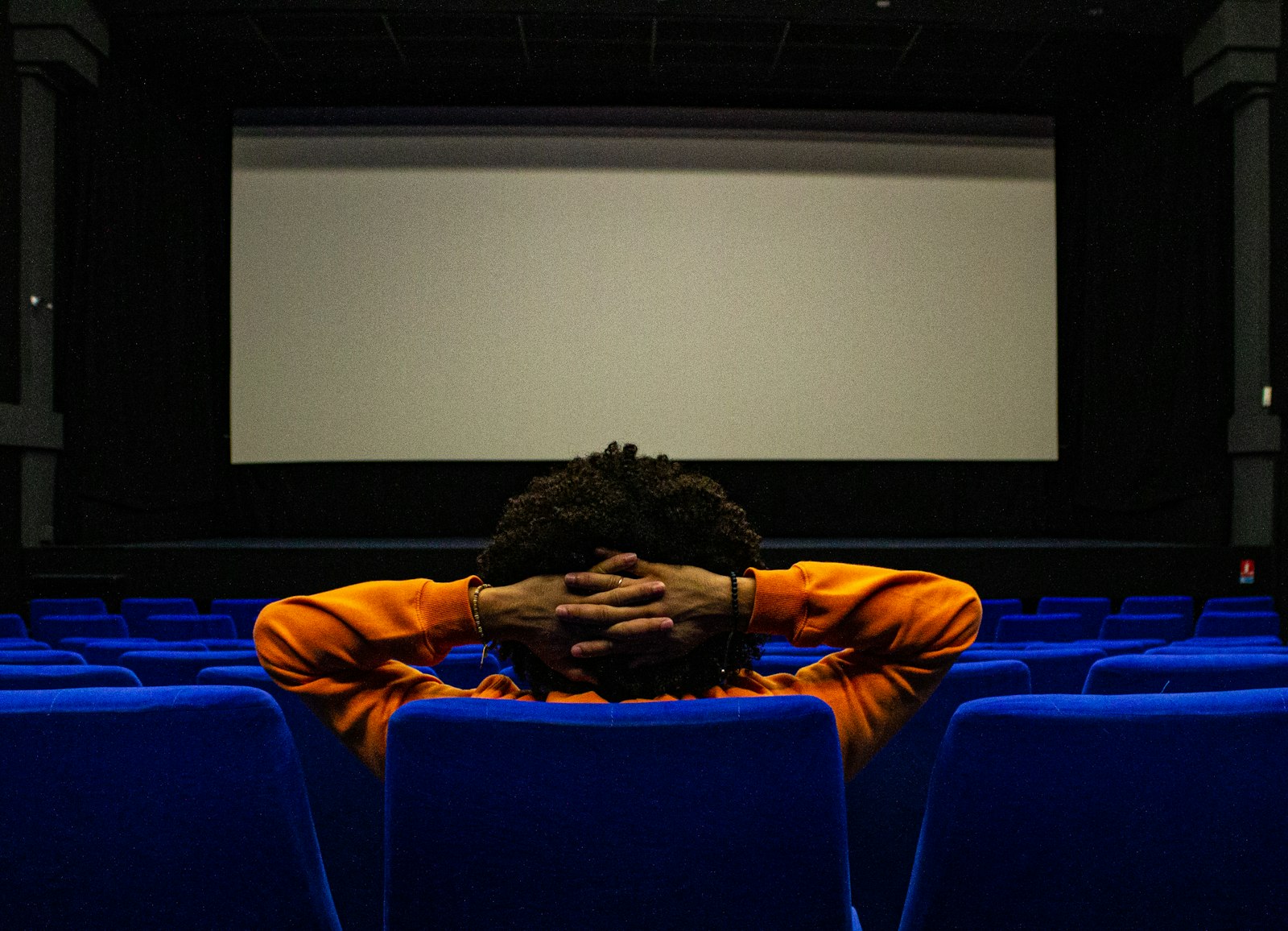 Personne assise seule devant un écran de projection éclairé