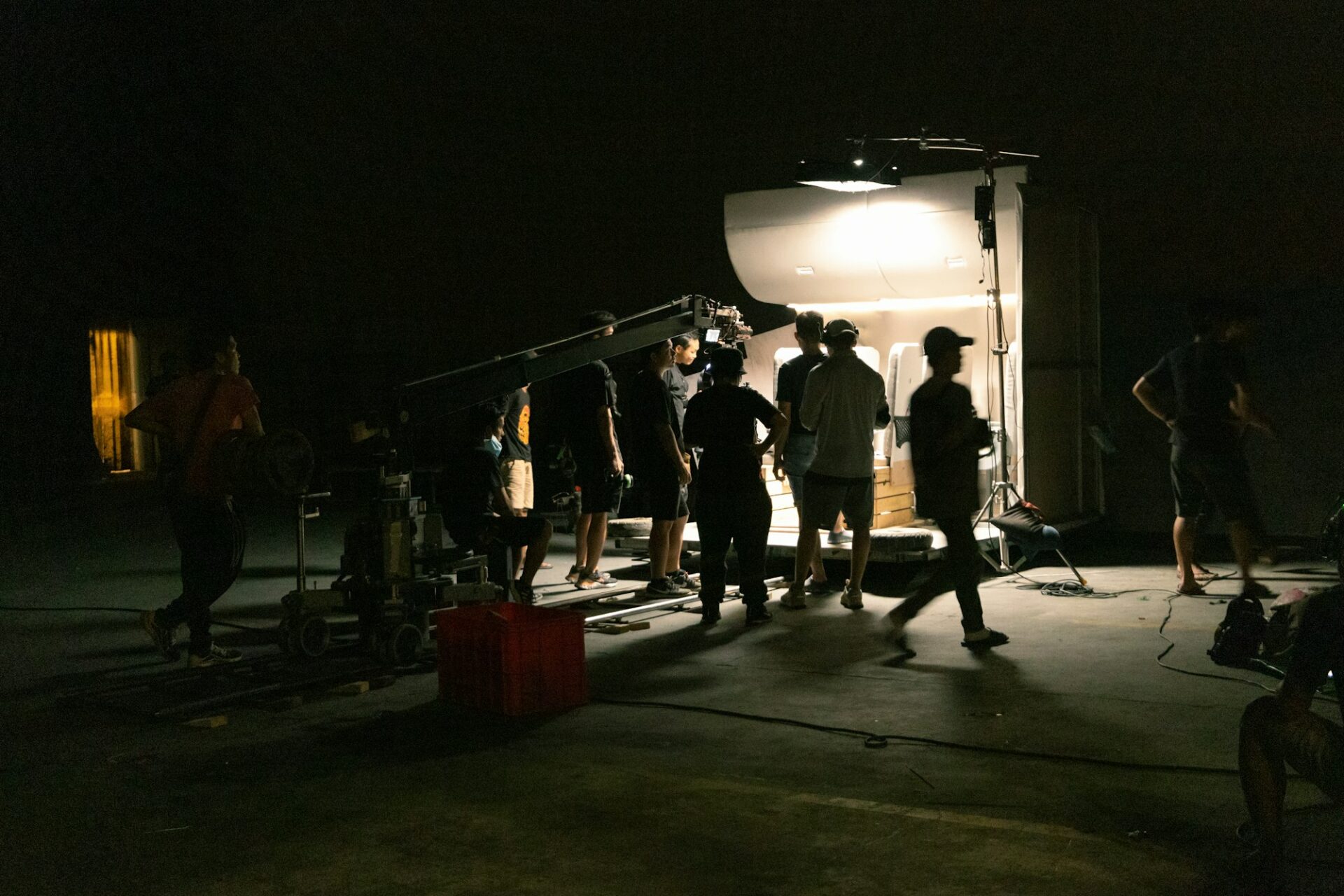 Équipe de tournage réunie autour d’une caméra dans la pénombre