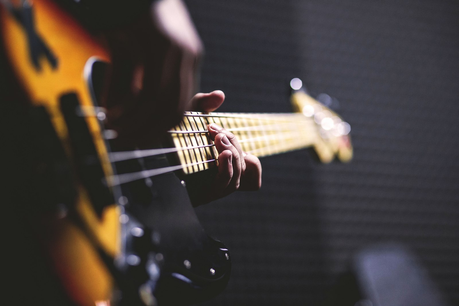 Gros plan sur les mains d’un musicien jouant de la basse