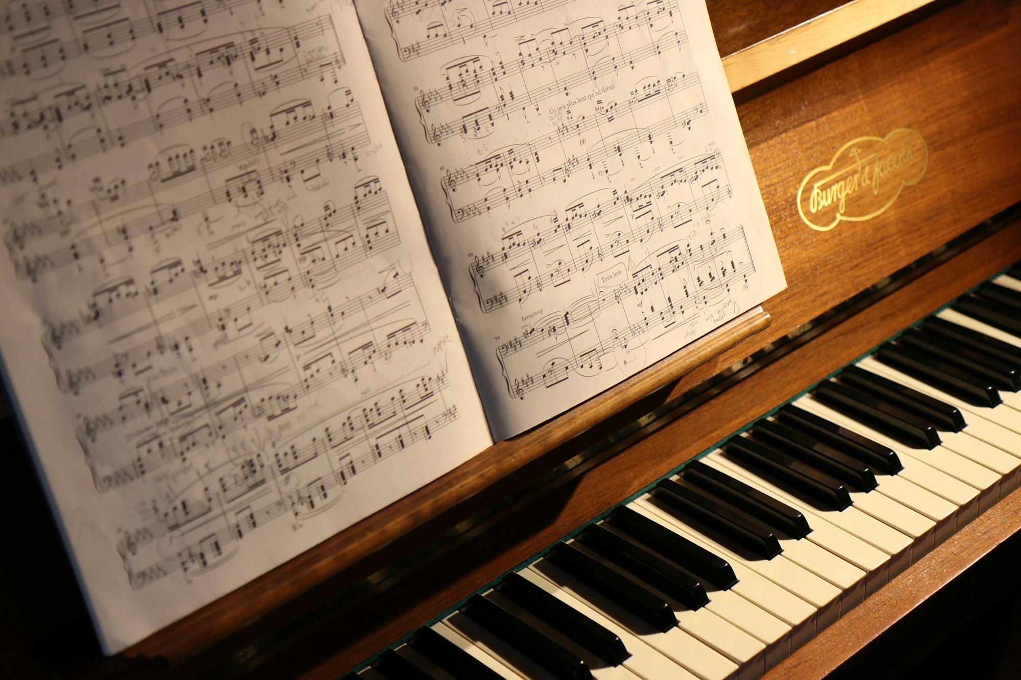 Partition posée sur le pupitre d’un piano droit en bois