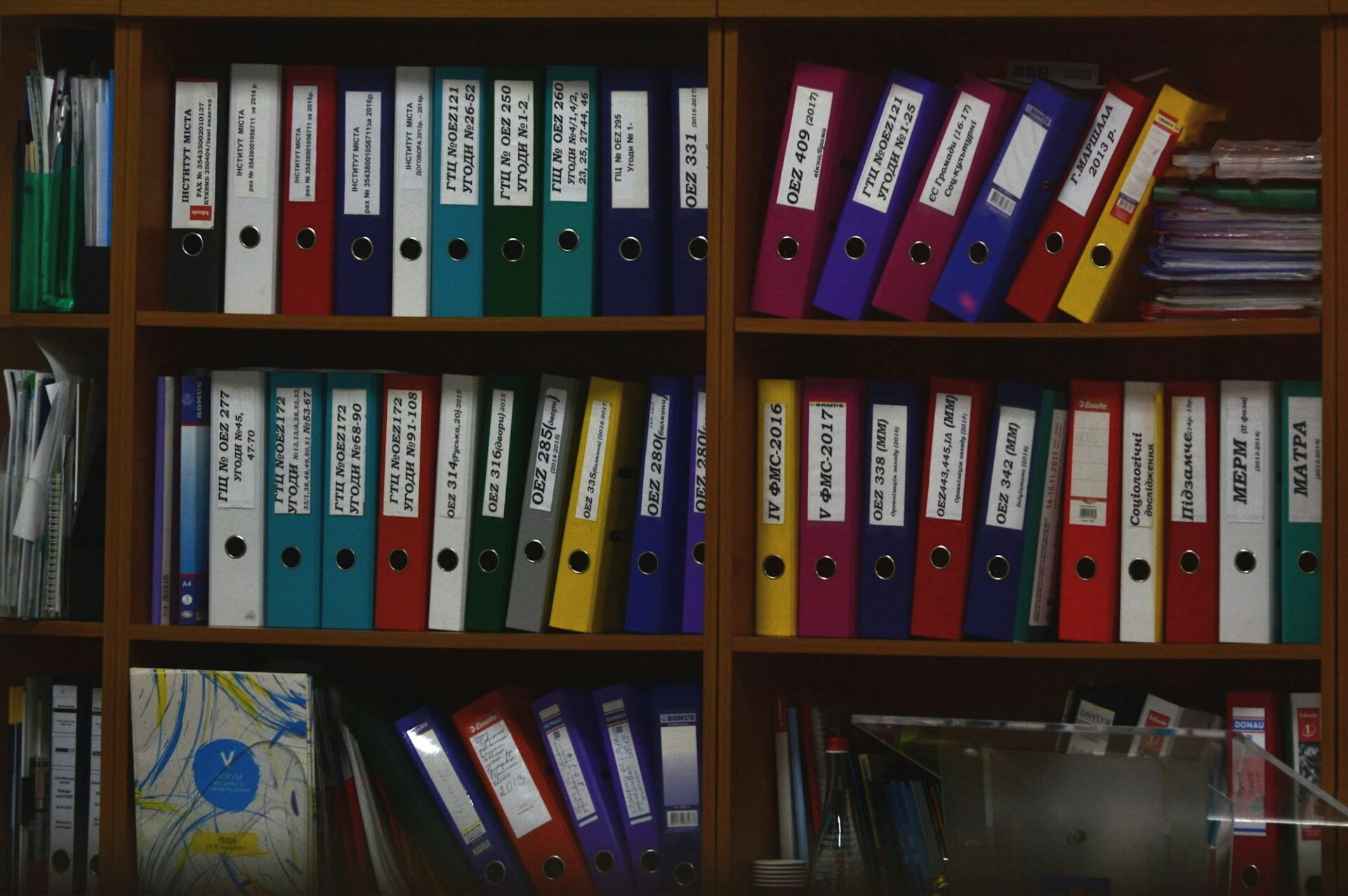 Rangées de classeurs colorés organisés sur des étagères en bois