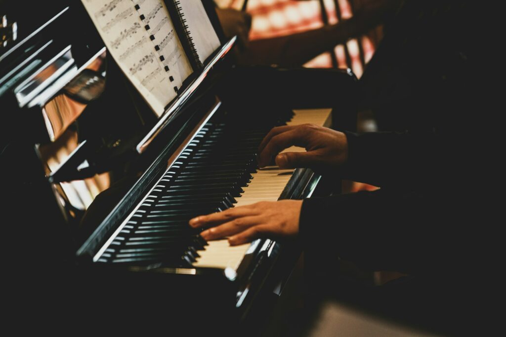 Musicien jouant du piano dans une pièce plongée dans la pénombre