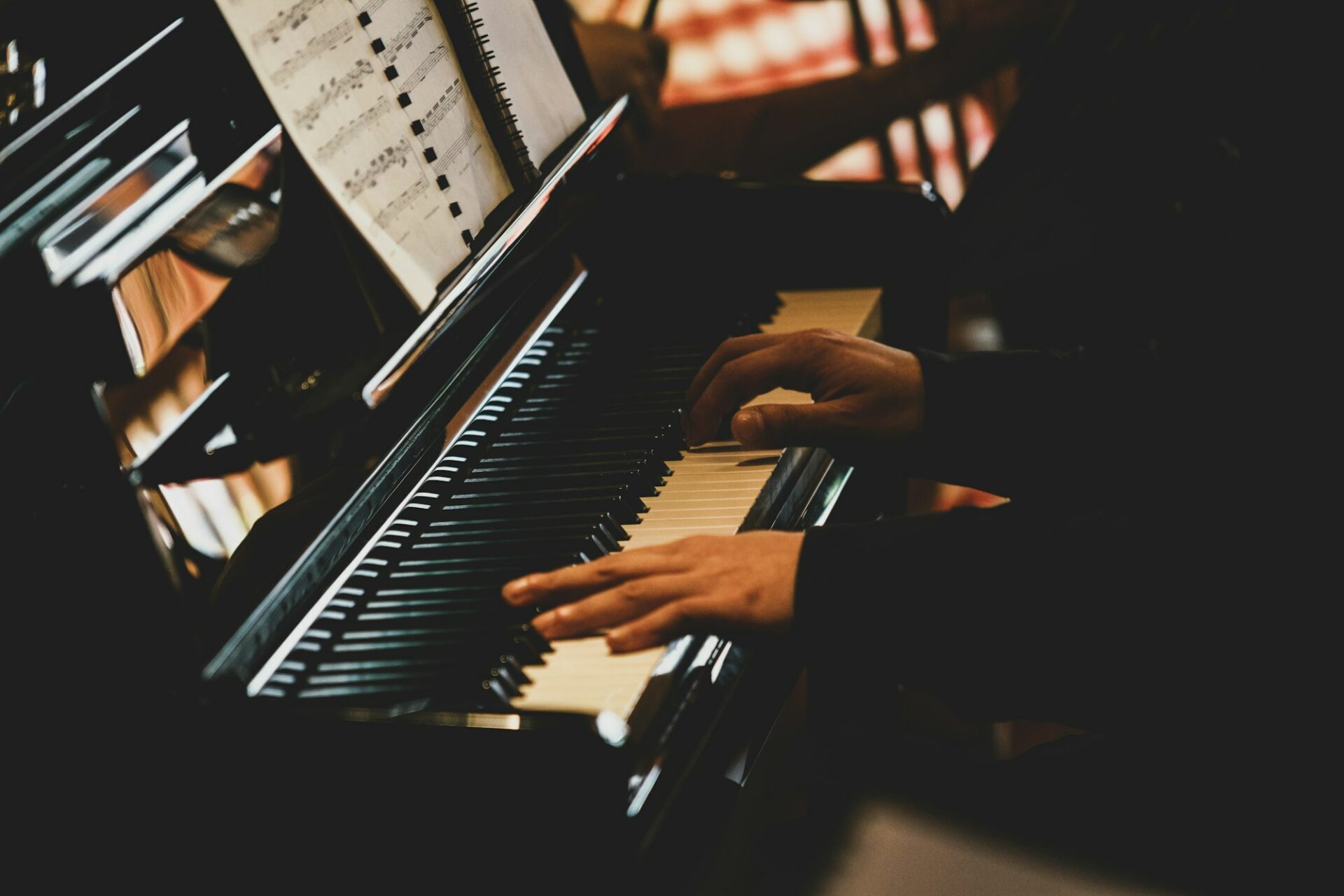 Musicien jouant du piano dans une pièce plongée dans la pénombre
