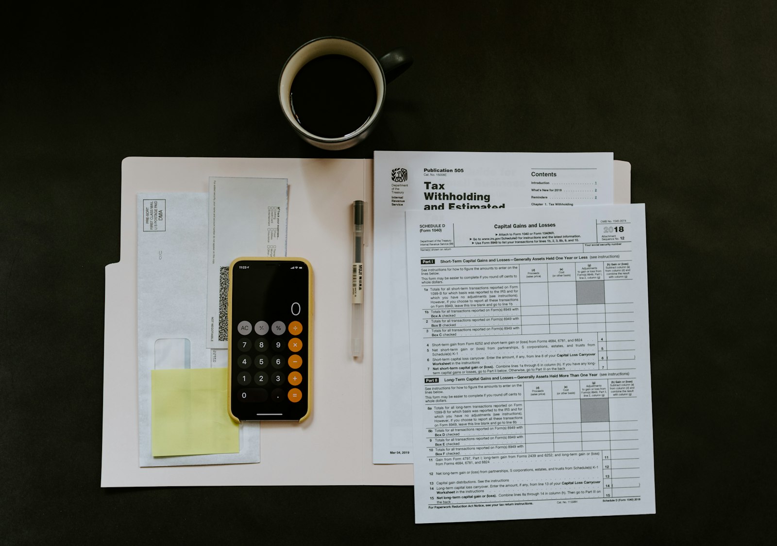 Téléphone et stylo posés sur un dossier de documents