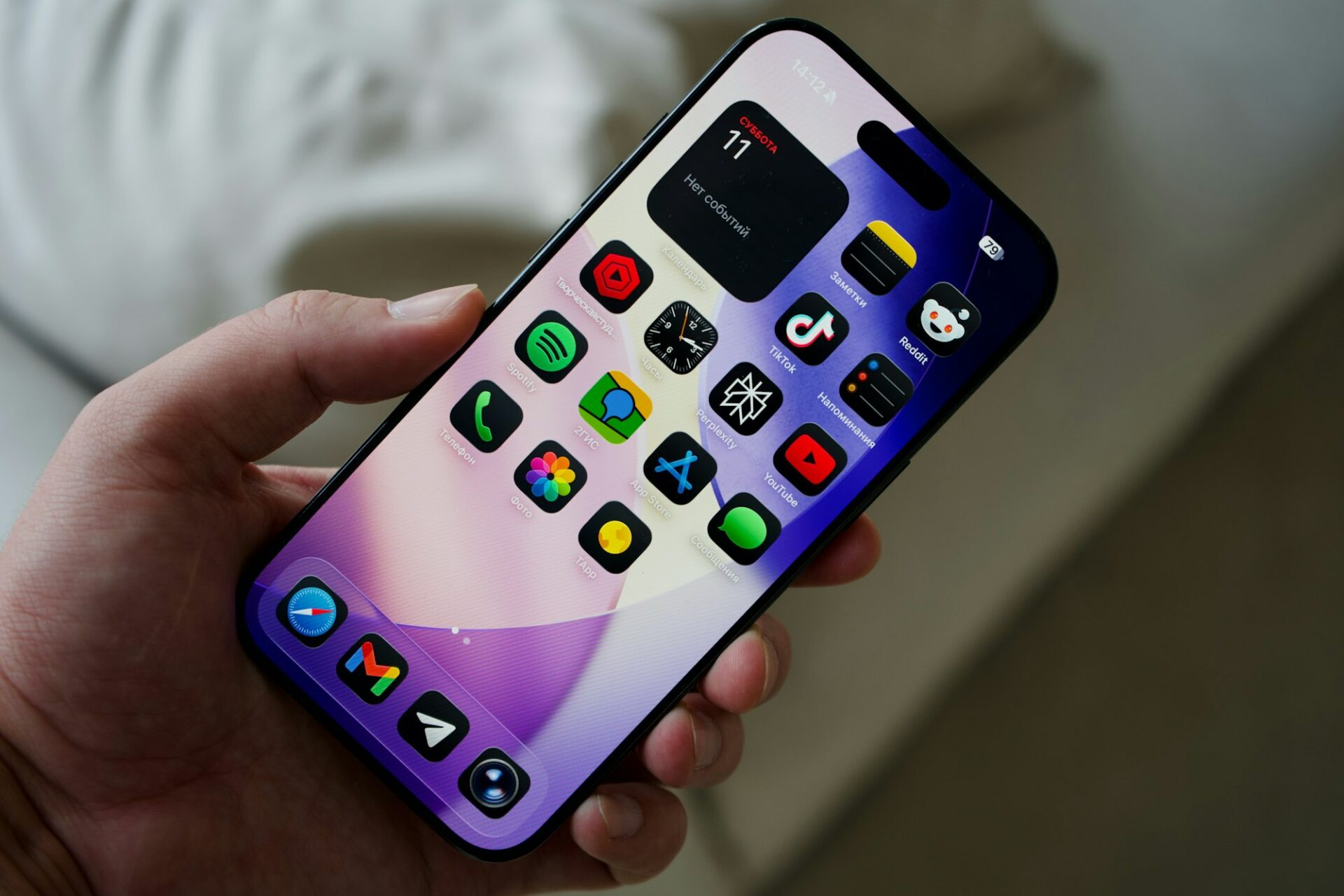 Main tenant un smartphone affichant des applications