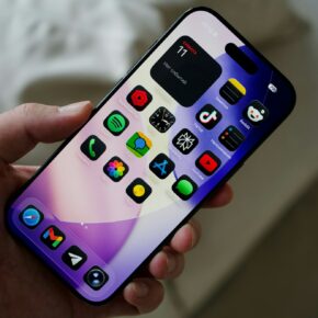 Main tenant un smartphone affichant des applications