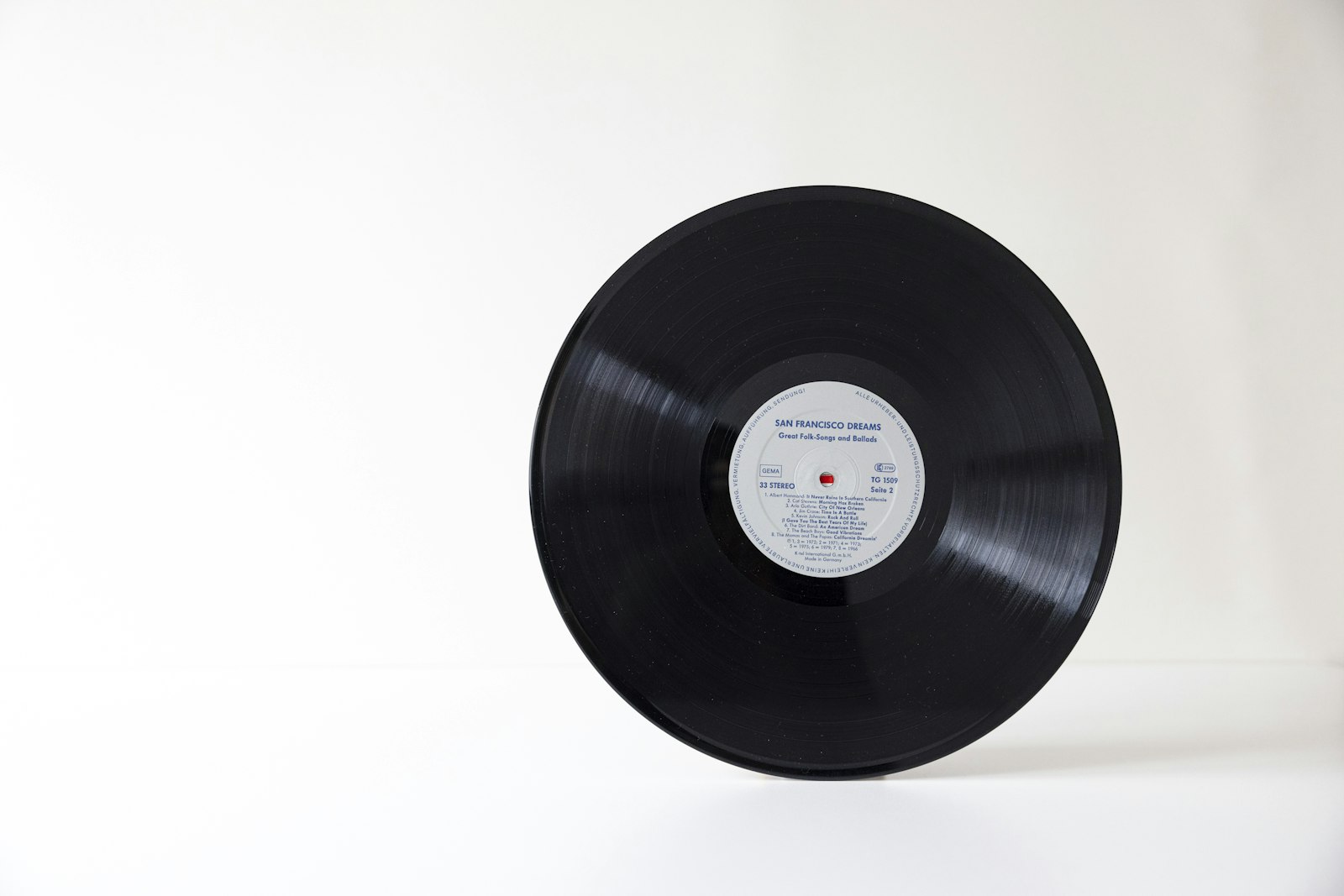Disque vinyle noir avec son étiquette centrale posé sur une surface blanche