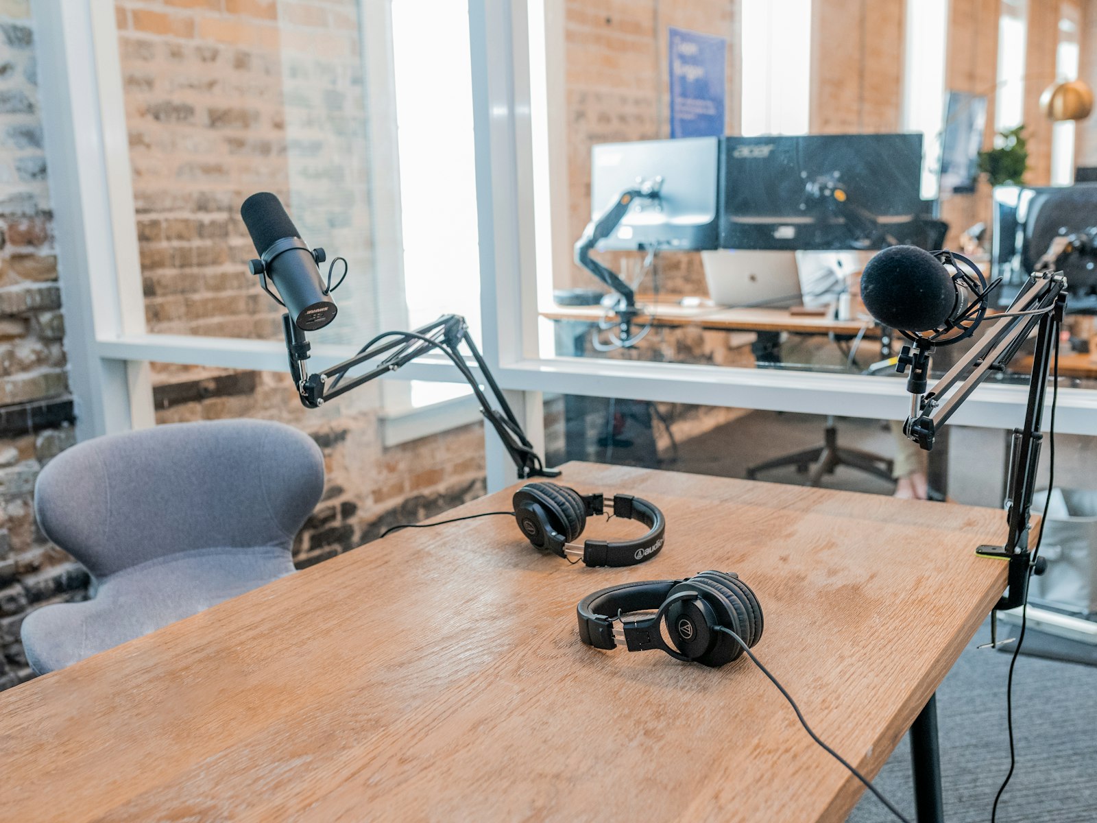 Deux casques audio posés sur une table en bois dans un studio de diffusion