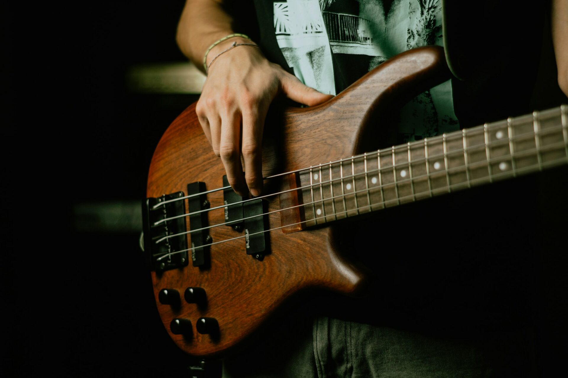 Musicien tenant une guitare électrique brune et noire