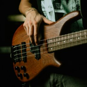 Musicien tenant une guitare électrique brune et noire