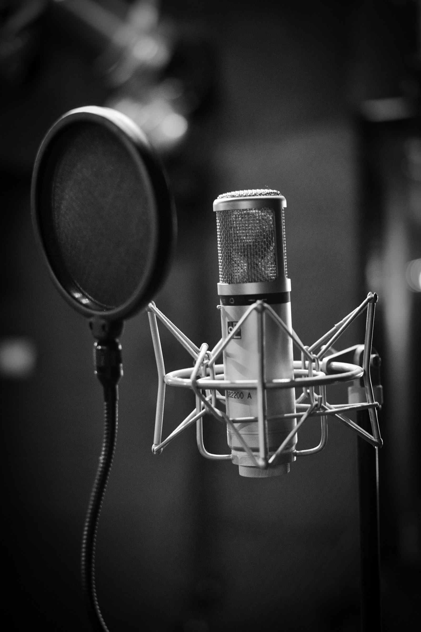 Microphone statique photographié en noir et blanc à côté d'un filtre anti-pop