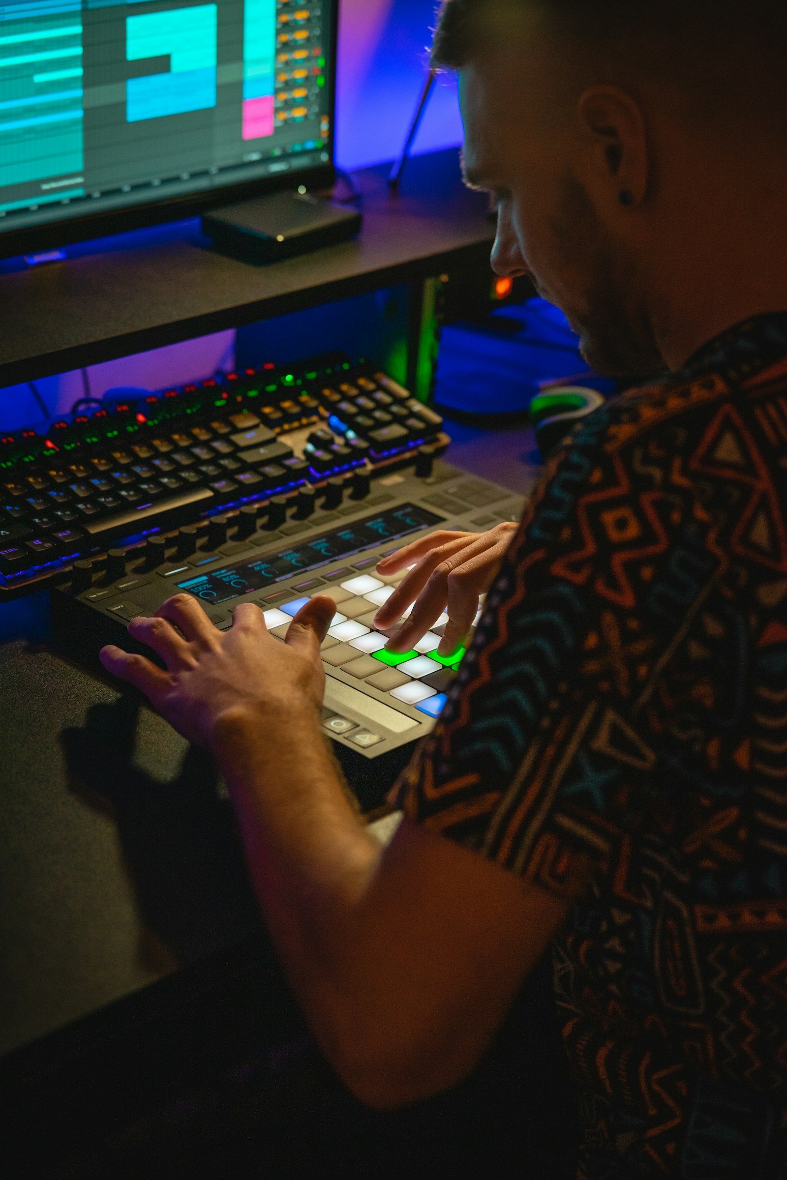 Homme créant de la musique sur un contrôleur dans un studio