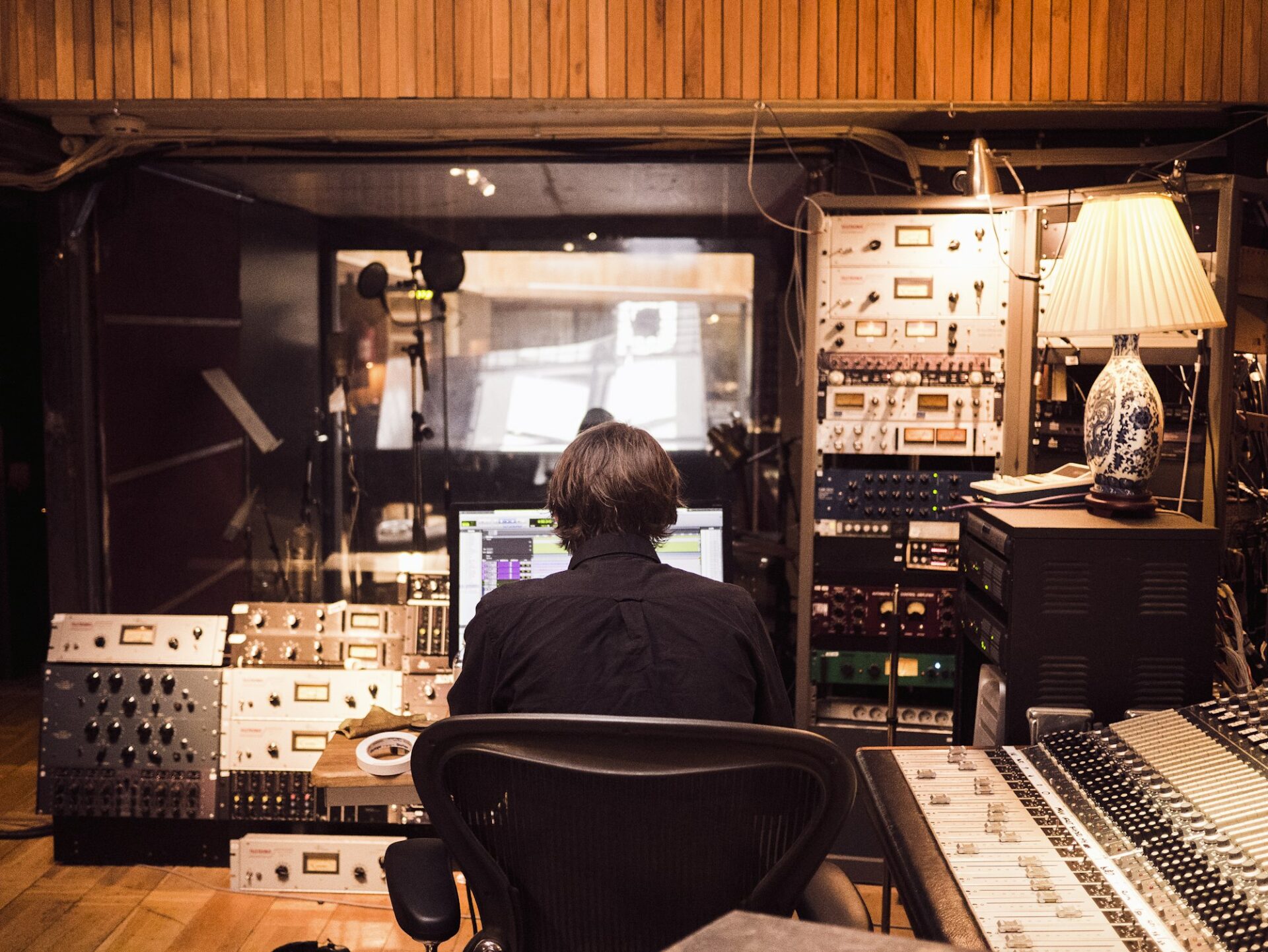 Ingénieur du son devant une console de mixage en régie