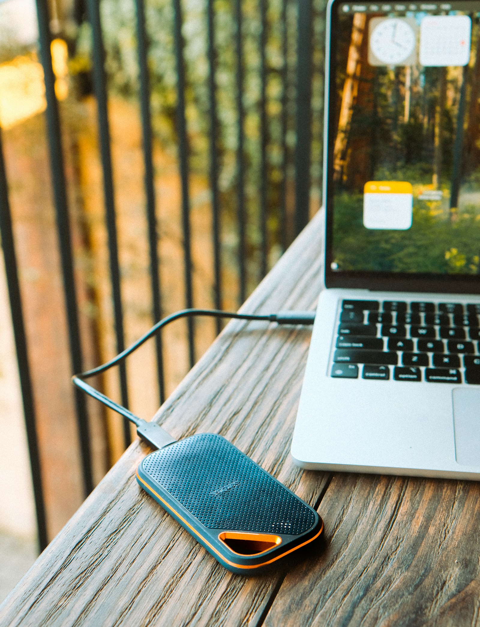 Disque dur externe portable branché à un ordinateur portable sur une table en bois