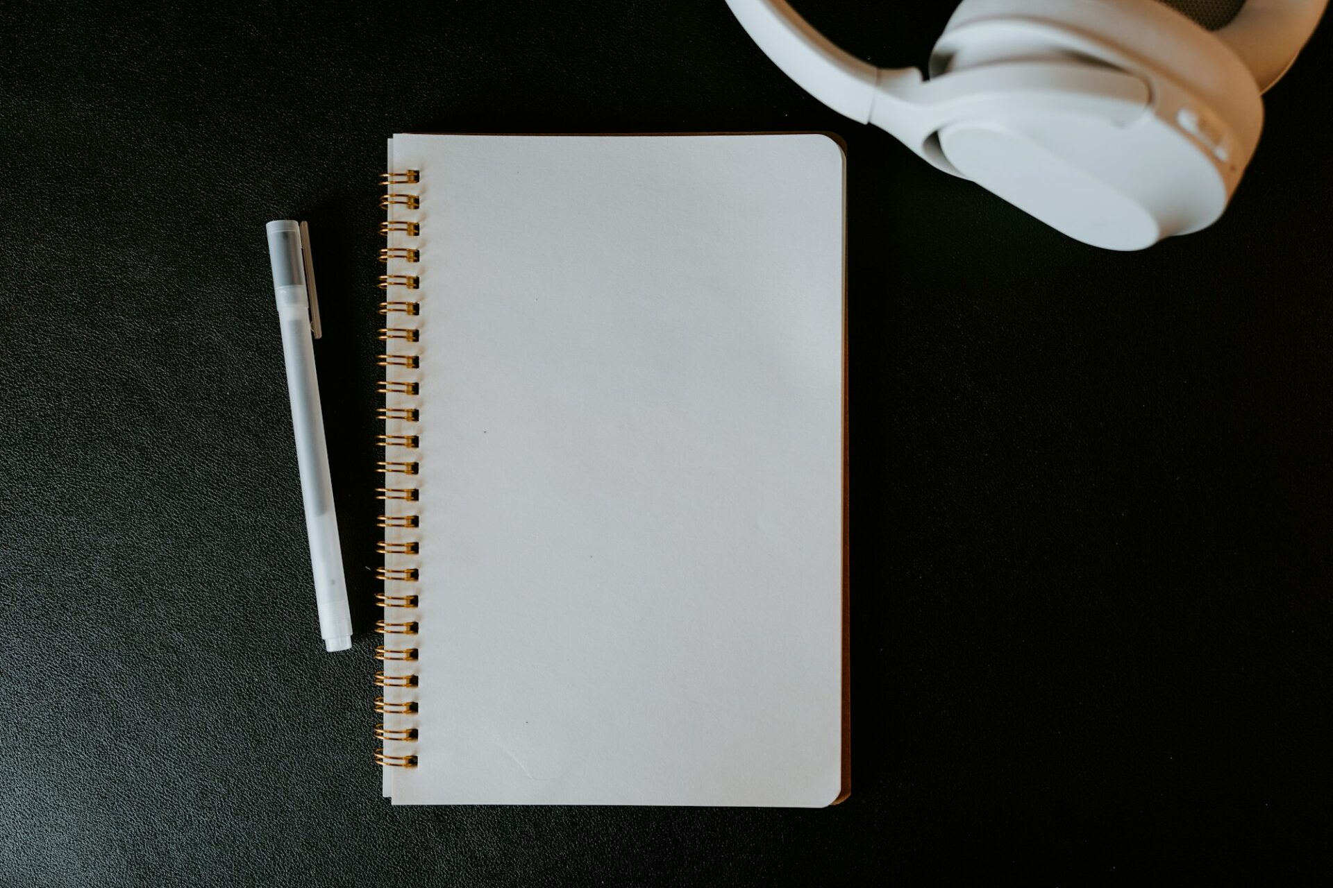 Carnet, stylo et casque audio posés sur une table